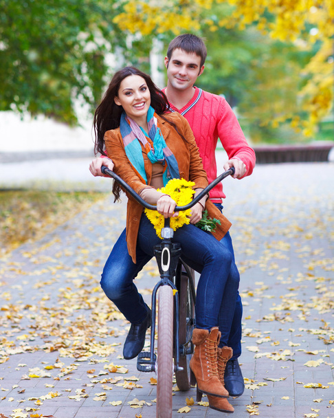 Happy couple with bicycle in autumn park - Photo, Image