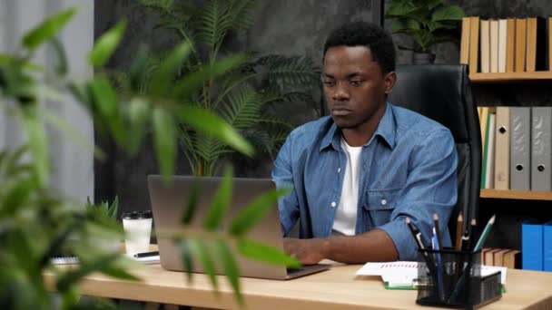 Афроамериканский бизнесмен работает в чате ноутбуков с сотрудниками компании - Кадры, видео
