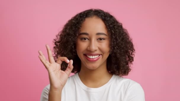 Fröhliche Afroamerikanerin gestikuliert auf rosa Hintergrund - Filmmaterial, Video