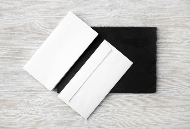 Blank white envelopes on stone board. Copy space. Flat lay. - 写真・画像