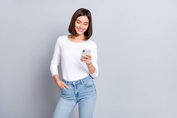 Photo of sweet bob hairstyle millennial lady look telephone wear shirt jeans isolated on grey color background - Fotoğraf, Görsel