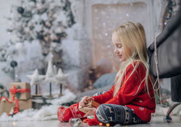 Joyeux Noël et Joyeuses Fêtes ! Le matin avant Noël. Portrait de petite fille heureuse portant un pull de Noël - Photo, image