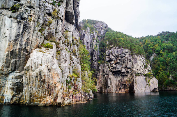 Formacja skalna w Lysefjord ze słynnym wodospadem Hengjanefossen - Zdjęcie, obraz