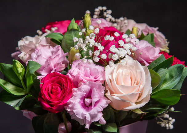 Όμορφο μπουκέτο από πολύχρωμα λουλούδια τριαντάφυλλο. Γιορτινή ιδέα λουλουδιών. Μπουκέτο με φρέσκα τριαντάφυλλα, φρέζιες, ευστόμα και άλλα. - Φωτογραφία, εικόνα