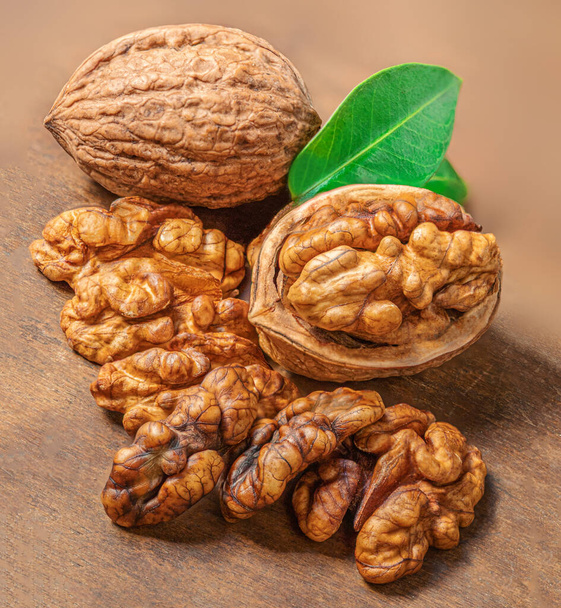 Walnut. Fresh Walnut kernel Nut on wooden background. Organic walnut with green leave - Zdjęcie, obraz