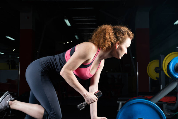 attractive young woman engaged with dumbbells in the gym. - 写真・画像