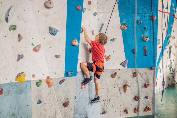 Boy at the climbing wall without a helmet, danger at the climbing wall - 写真・画像