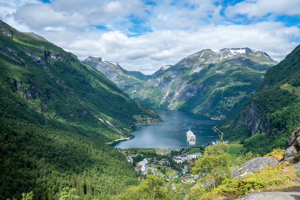 Beautiful summer view over the Geiranger fjord in norway with steep mountainsides on a sunny summer day. A large ocean liner anchoring in the bay - Foto, immagini