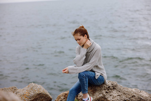 πορτρέτο μιας γυναίκας πουλόβερ συννεφιασμένη θάλασσα θαυμάζοντας τη φύση έννοια χαλάρωσης - Φωτογραφία, εικόνα