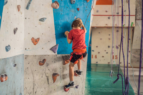 Boy at the climbing wall without a helmet, danger at the climbing wall - Photo, image