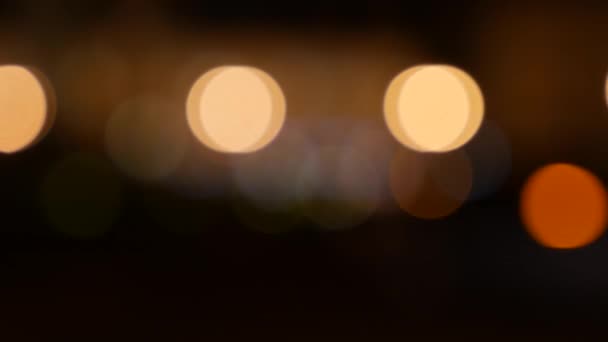 Beautiful glittering bokeh in dark blurry background at night. The round colorful bokeh shine from car lights on city street. Out of focus with blurry. Unfocused city lights. Traffic bokeh. Abstract - Footage, Video