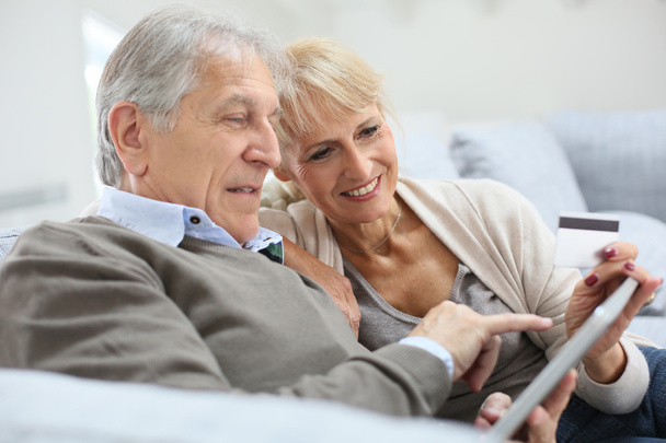 Senior couple e-shopping with tablet - Foto, afbeelding