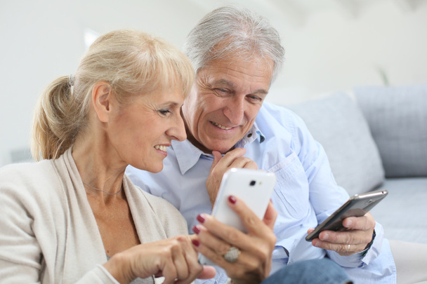 Couple at home using smartphone - Photo, image