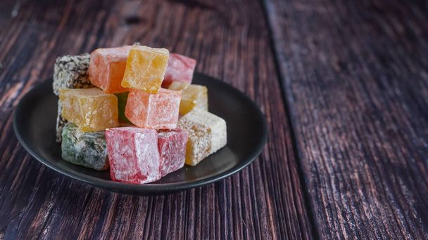 Turkish delight on a dark wood background. selective focus. Front view. - Photo, Image
