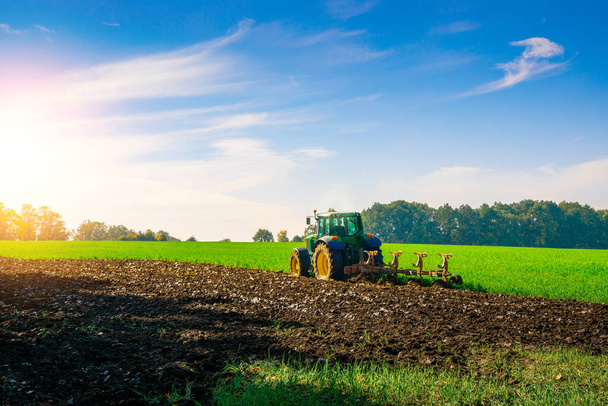 トラクター収穫。風景の土地のフィールド上の農業機械。作物のための農業機械機器。工業農業の概念 - 写真・画像