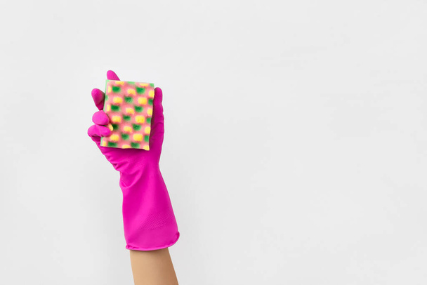 Womans hand in pink rubber glove holding sponge background. - Photo, Image