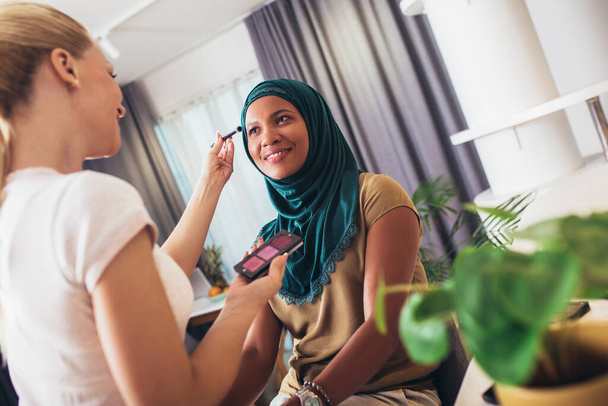 A make-up artist makes up a Muslim woman at home. - Φωτογραφία, εικόνα