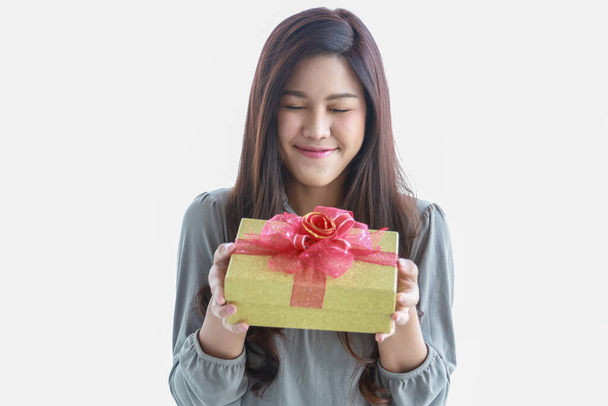 Feliz Año Nuevo, Navidad y el concepto de temporada de vacaciones. Retrato de joven asiática sonriente mujer cerrar los ojos y sosteniendo una hermosa caja de regalo. - Foto, Imagen