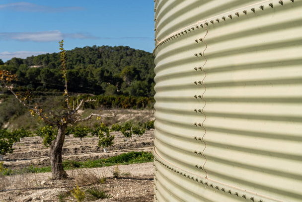 Superficie metallica di un serbatoio d'acqua accanto a un campo agricolo. - Foto, immagini