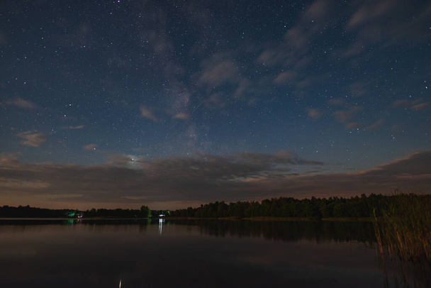 Lake by the forest under the starry summer sky in the moonlight - Fotoğraf, Görsel