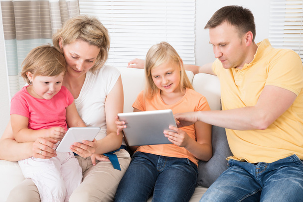 Nuori perhe käyttäen Tablet yhdessä
 - Valokuva, kuva