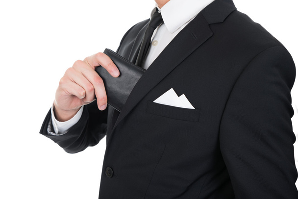 Homme d'affaires mettant portefeuille dans sa poche
 - Photo, image