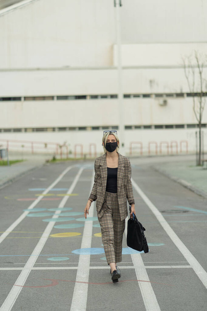 Krásná podnikatelka kráčí ke společnosti se svou ochrannou maskou na hlavě - Fotografie, Obrázek