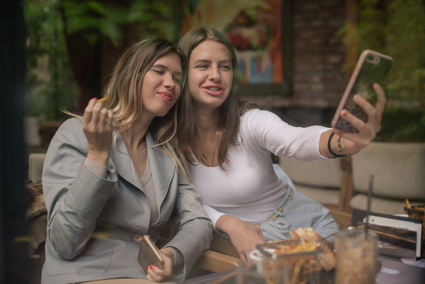 Úžasné a atraktivní dívky dělají selfie při jídle - Fotografie, Obrázek