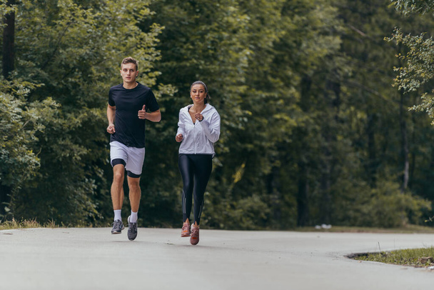 Atletický pár běžící na ulici vedle sebe. Příroda, fit a zdravý koncept. - Fotografie, Obrázek