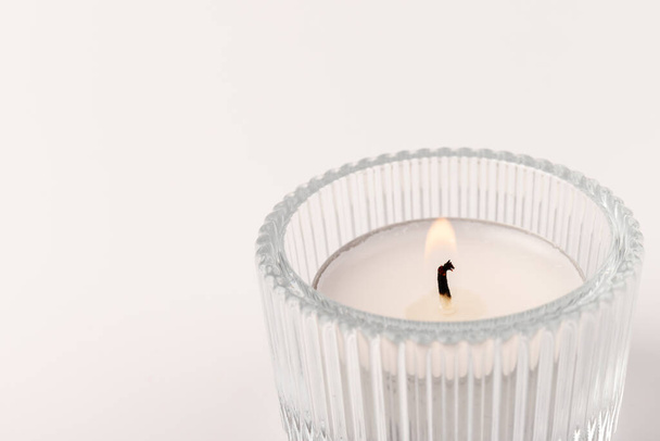 Small burning wax candles in a glass candlestick, isolated on white. Beautiful decor. - Photo, Image