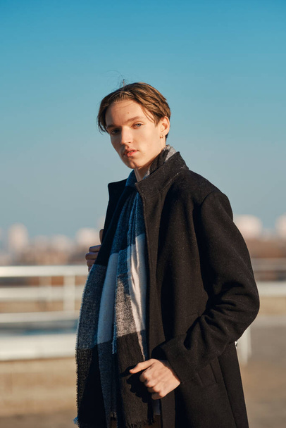 Young man in old wool coat, scarf and short trousers outdoor with hand in the pocket - Foto, immagini