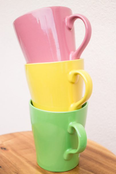 Кухоль солодкого кольору чашки на дерев'яному столі
 - Фото, зображення