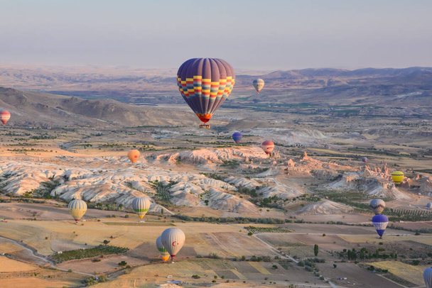 Amazing balloons soaring at sunrise among the bizarre mountains of Cappadocia - Фото, зображення