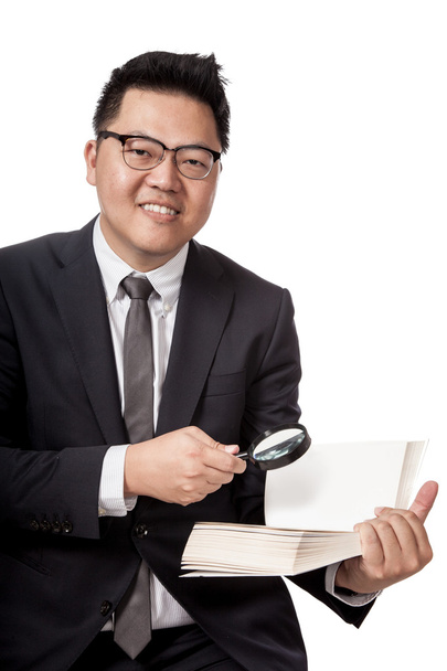 Asian businessman with book and magnifying glass smiling - Foto, Bild
