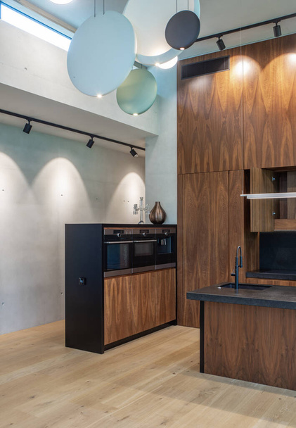 Modern interior of wooden kitchen with sink and black counter. - Φωτογραφία, εικόνα