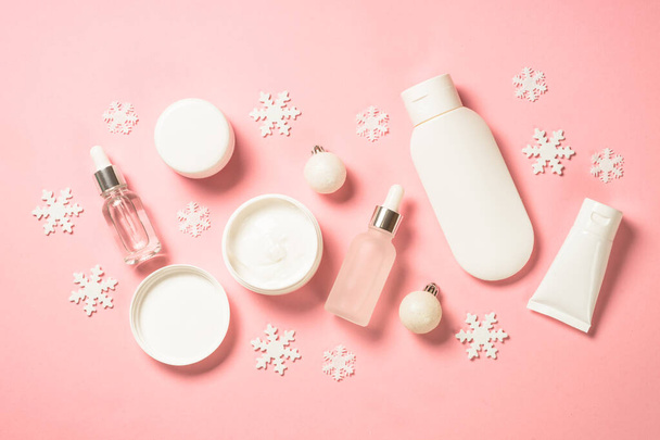 Winter cosmetic, skin care product on pink background. - Фото, изображение