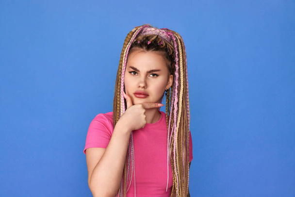 unsatisfied woman with dreadlocks on blue background. - Foto, immagini