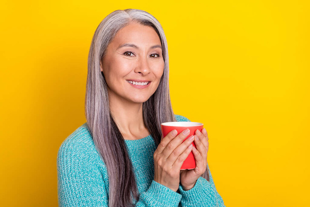 Portrait of attractive cheery grey-haired woman drinking tea copy space isolated over bright yellow color background - Foto, Imagem