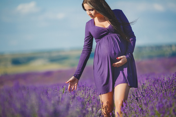 A pregnant woman is enjoying the color Lavender - Фото, изображение