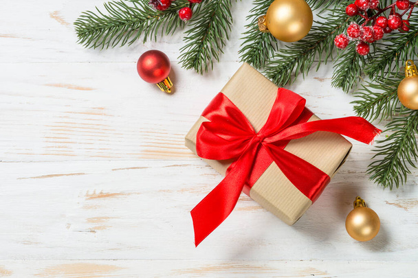 Χριστουγεννιάτικο κουτί δώρου με κόκκινη κορδέλα και διακόσμηση διακοπών. - Φωτογραφία, εικόνα