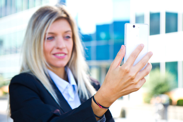 Beautiful business woman takes a selfie with her cell phone - Fotografie, Obrázek