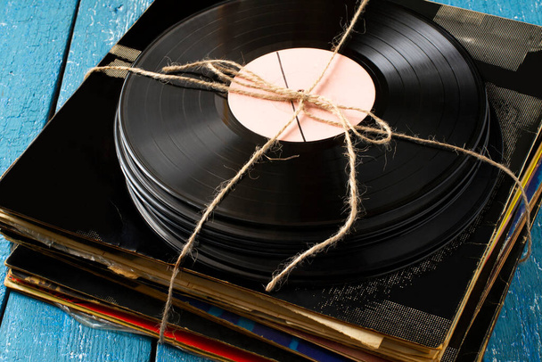 Montón de viejos discos de vinilo atados con cordel. Vinyl records and album covers from the 70s and 80s (en inglés). Recuerdos del pasado. Colección retro de música - Foto, Imagen