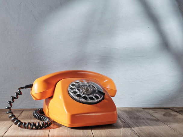 Orange vintage telephone on gray background - Foto, afbeelding