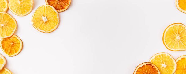 Christmas Banner. winter, new year composition. Slices of dry oranges on white background. Natural Citrus fruits pattern. Food background. Flat lay, top view, copy space - Photo, image