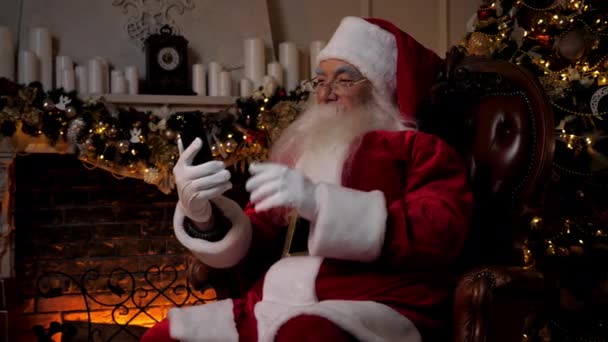 Moderni hymyilevä Joulupukki tervehtii puhuu lapsille verkossa älypuhelin video puhelu - Materiaali, video