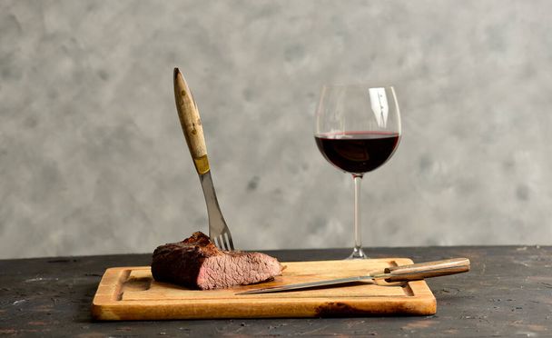 Costeletas de carne assada com um copo de vinho tinto apresentado na mesa, cozinha tradicional argentina, churrasco Asado, Patagônia, Argentina. - Foto, Imagem