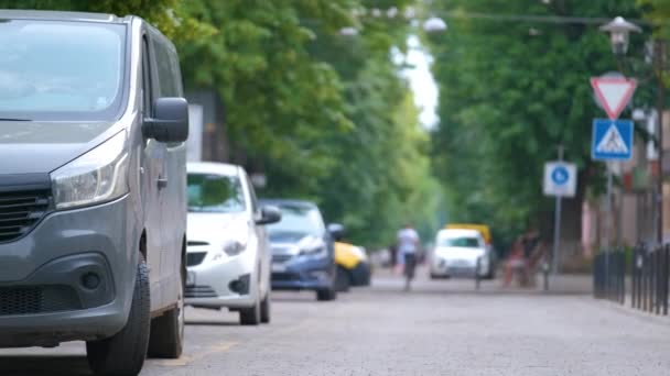 Κυκλοφορία στην πόλη με τα αυτοκίνητα σταθμευμένα στην ουρά στην πλευρά του δρόμου - Πλάνα, βίντεο