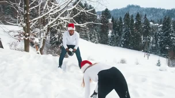 Combattimento con le palle di neve. Giovane coppia godendo di giochi di neve in un giorno di Natale - Filmati, video