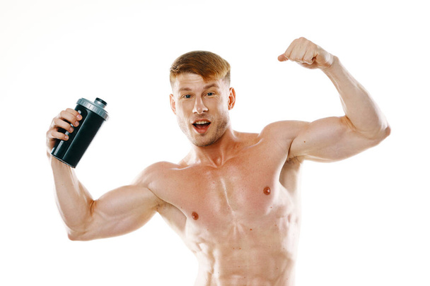 athletic man with pumped up muscular body sports drink light background - Fotografie, Obrázek
