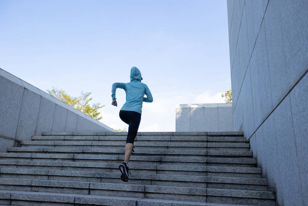 Fitness sports woman running up stairs in city - Foto, imagen